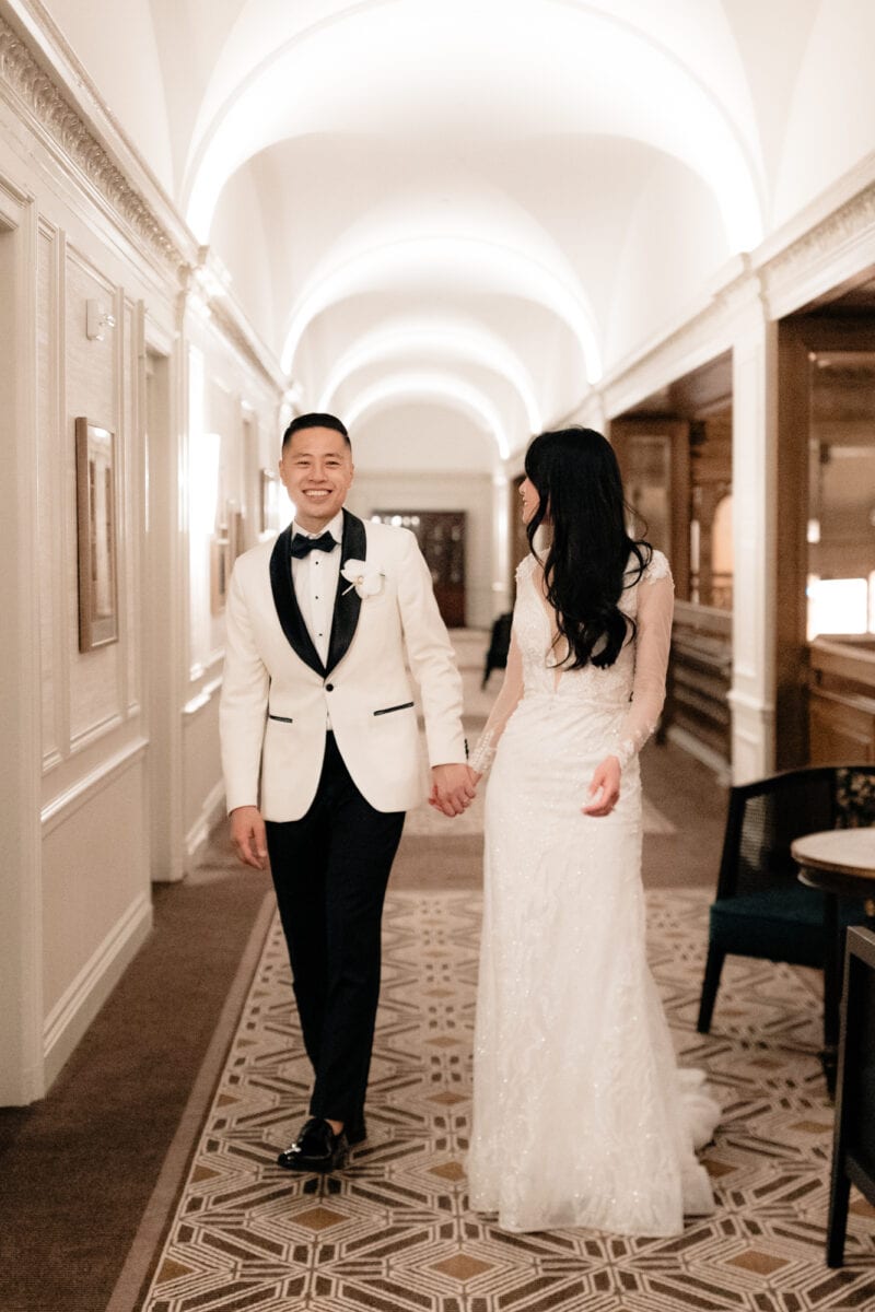 A wedding couple walking down the hall at a Fairmont Olympic wedding.