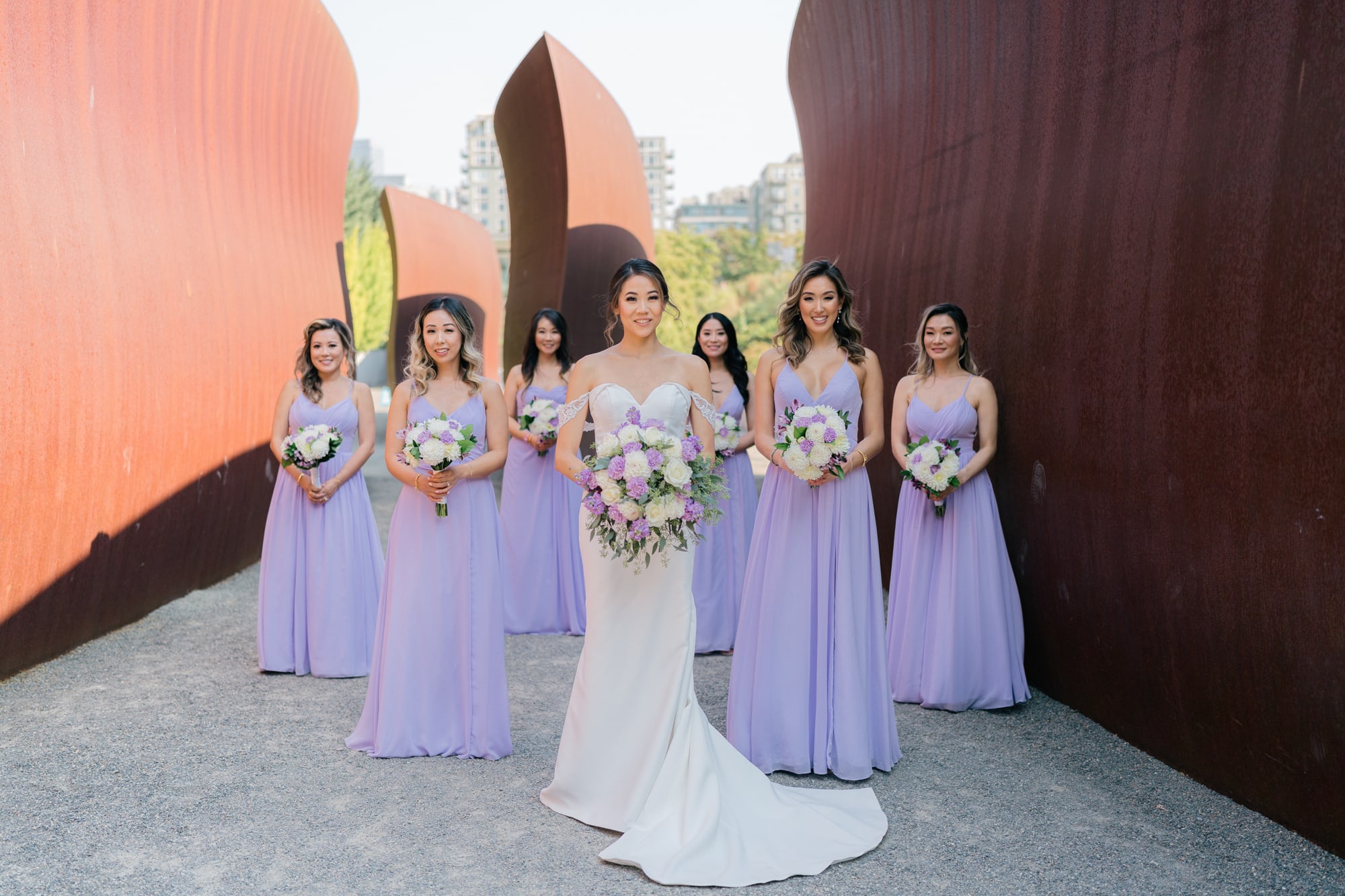 A bride posing with her bridesmaids in a formal bridal party photo at Olympic Sculpture Park in Seattle.