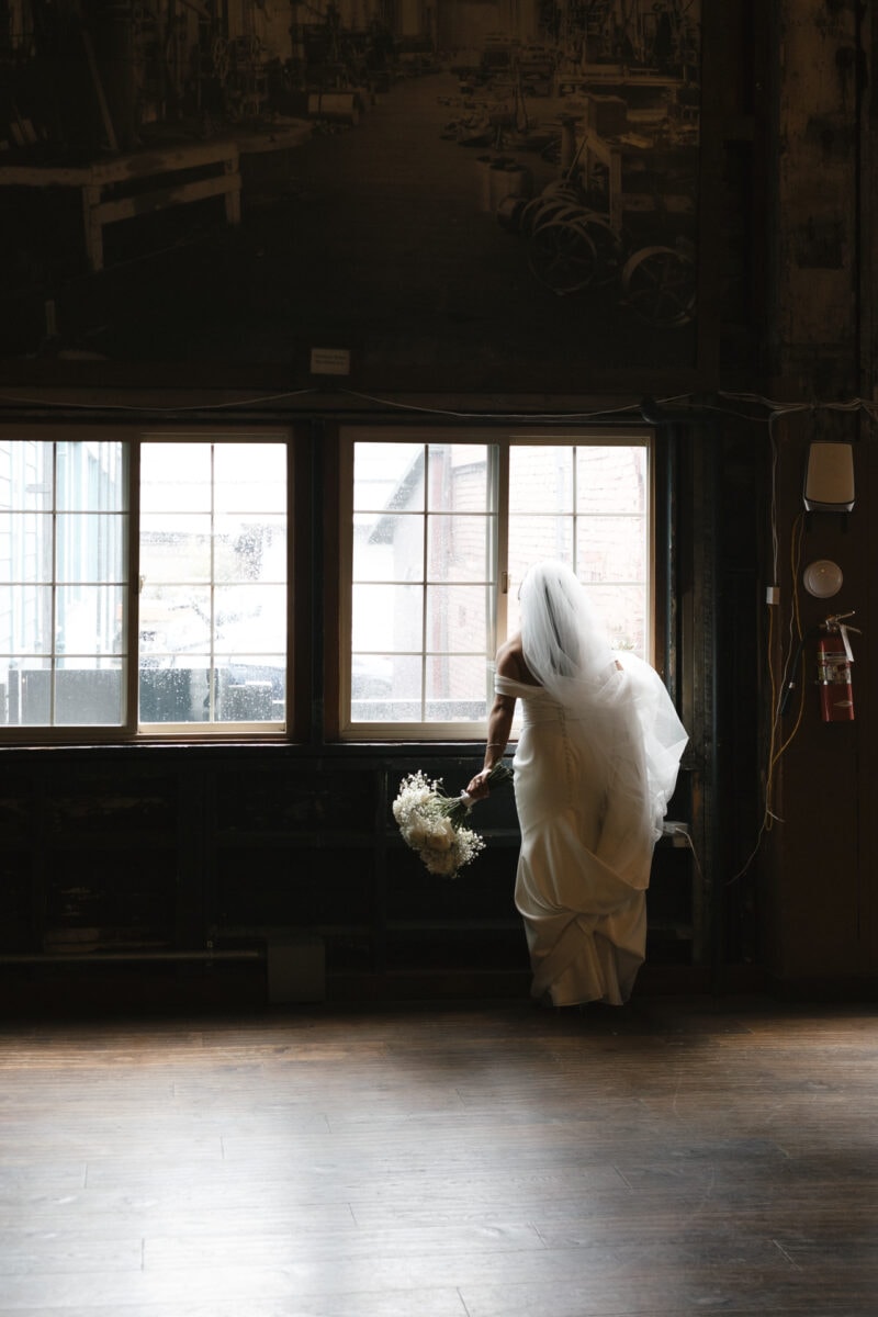 A bride looking out of the window before her Sodo Park Seattle wedding.