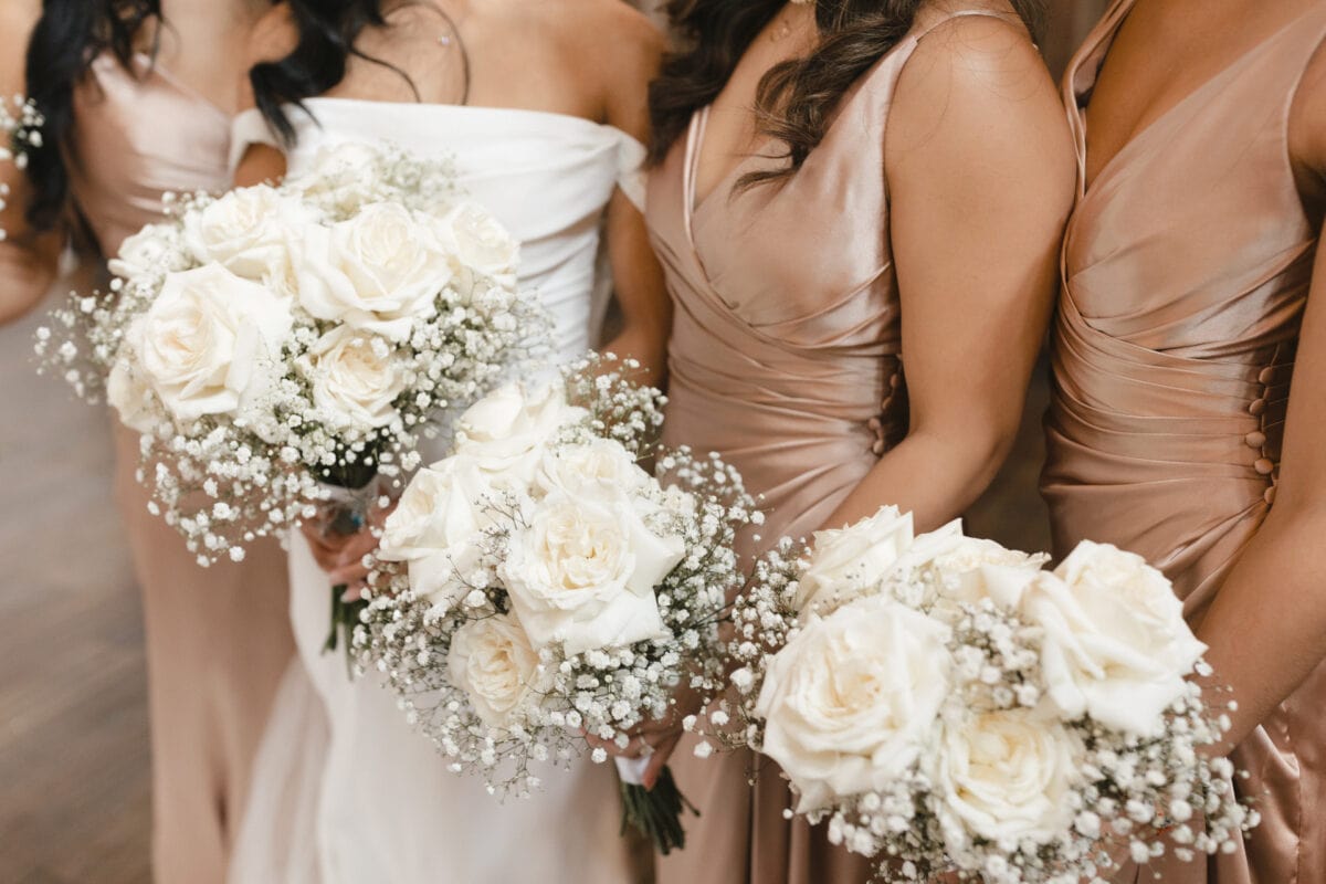 Bridesmaids holding up bouquets for bridal party photos at Sodo Park Seattle.