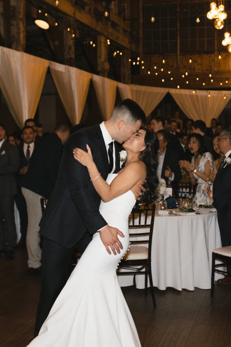 A wedding couple embracing in a kiss during their first dance at their Sodo Park Seattle wedding.